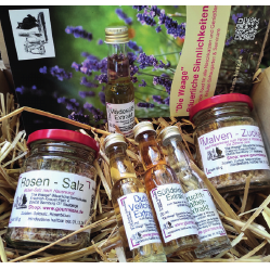 Flaschen und Gläser auf Stroh im Karton